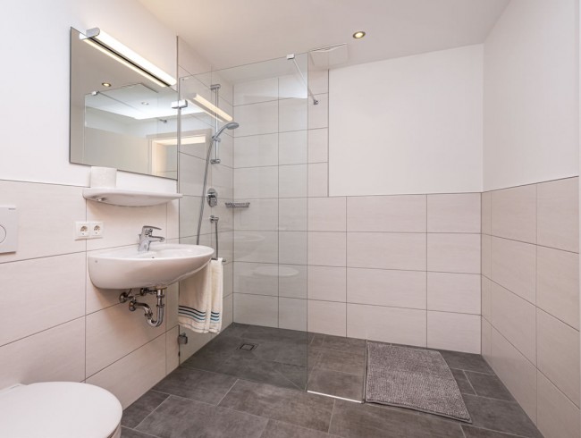 Badezimmer mit Waschbecken, Dusche und WC